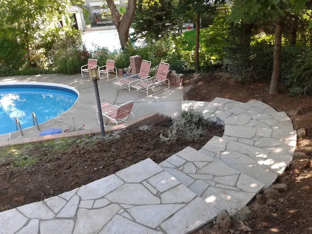 Backyard after new flagstone steps descending to the pool are installed