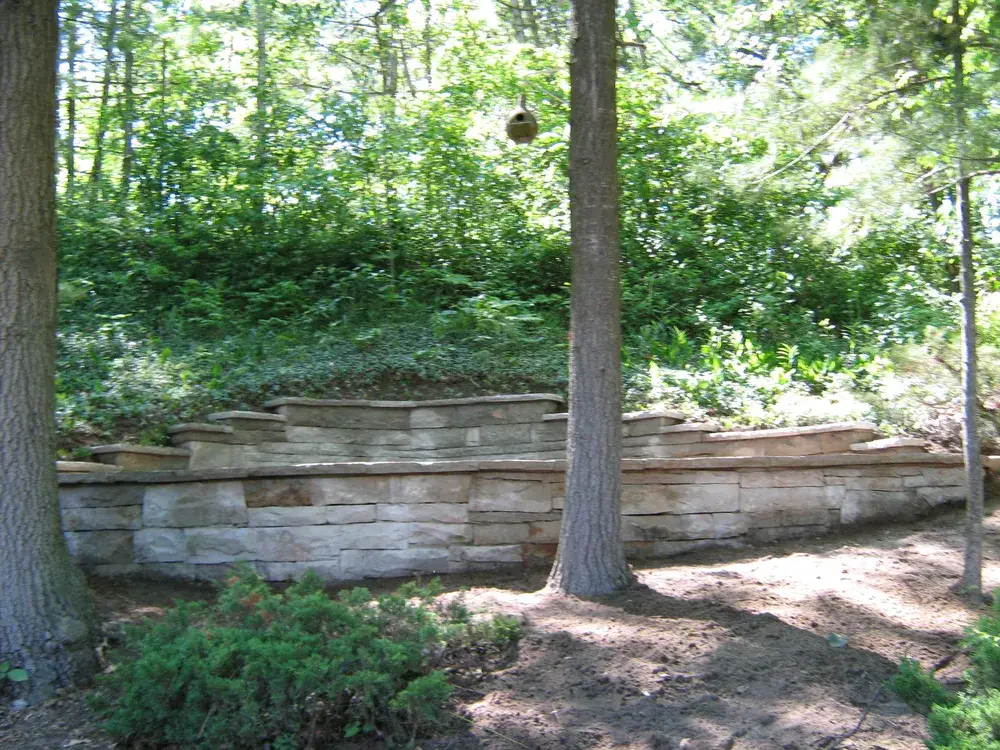 Backyard natural stone retaining wall installed