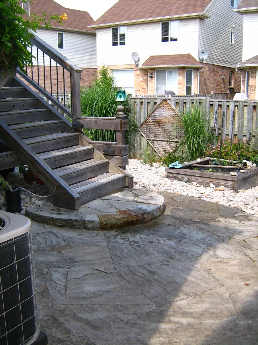 Flagstone patio and half circle stone landing coming off a wooden deck