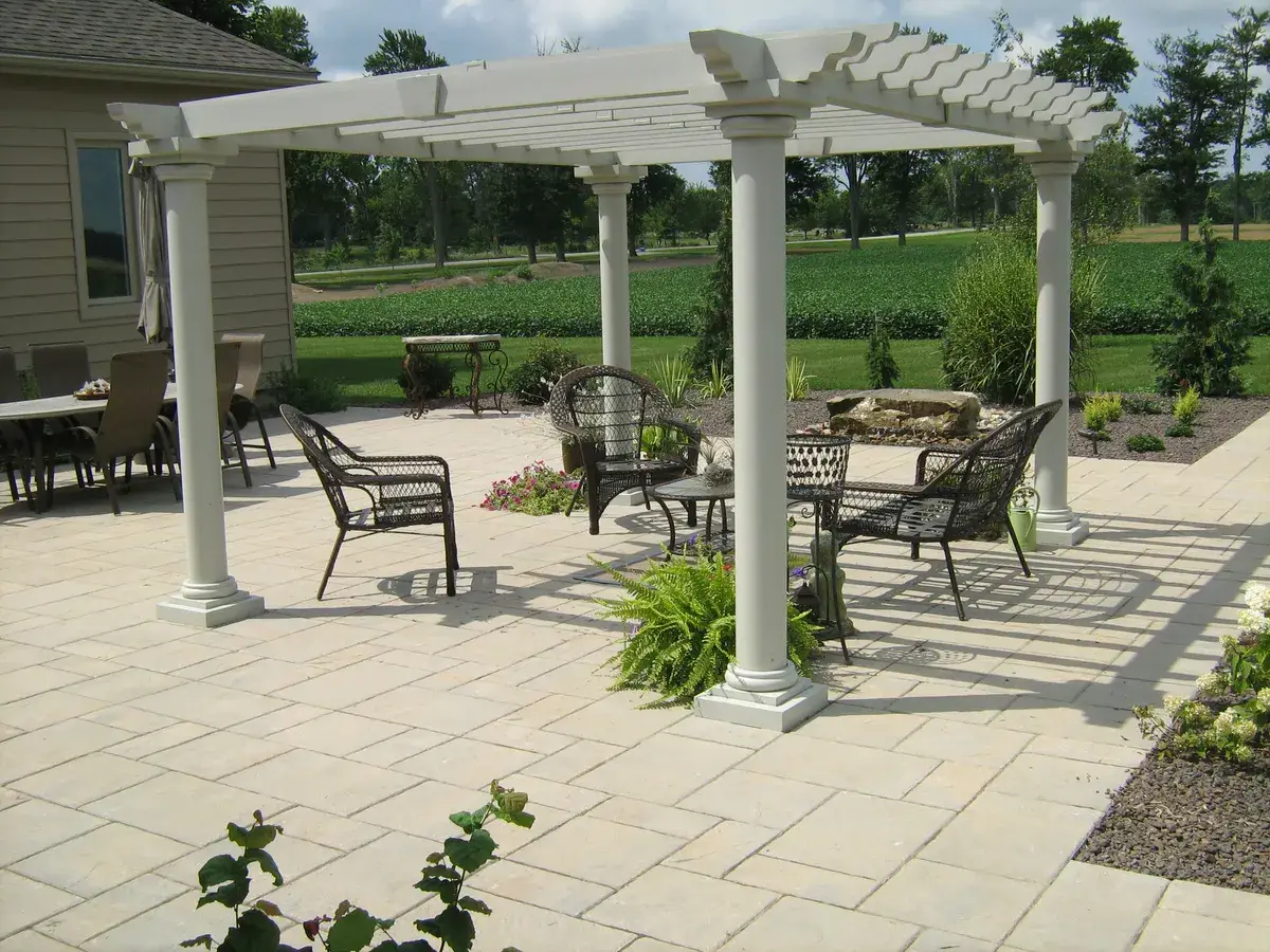 A stone patio seating area with gardens